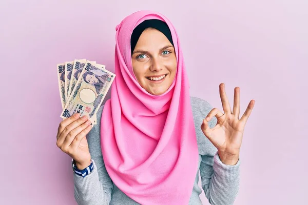 Νεαρή Καυκάσια Γυναίκα Φορώντας Ισλαμική Μαντίλα Κρατώντας Ιαπωνικά Χαρτονομίσματα Γιεν — Φωτογραφία Αρχείου