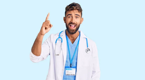 Joven Hombre Hispano Con Uniforme Médico Estetoscopio Apuntando Con Dedo —  Fotos de Stock