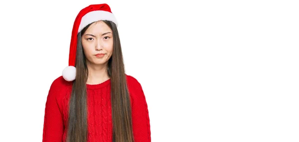 若い中国人女性のクリスマスの帽子懐疑的かつ神経を着て 問題のために動揺を眉をひそめる 否定的な人 — ストック写真