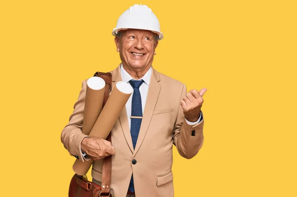 Senior Caucasian Man Wearing Safety Helmet Holding Blueprints Pointing Thumb — Stock Photo, Image