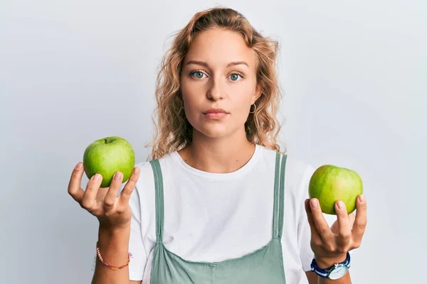 Όμορφη Λευκή Γυναίκα Που Κρατάει Πράσινα Μήλα Χαλαρά Σοβαρή Έκφραση — Φωτογραφία Αρχείου