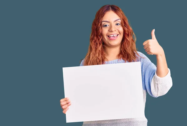 Mujer Latina Joven Sosteniendo Banner Vacío Blanco Sonriendo Feliz Positivo —  Fotos de Stock