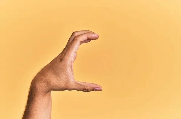 Рука Рука Кавказца Желтом Изолированном Фоне Собирают Берут Невидимую Вещь — стоковое фото