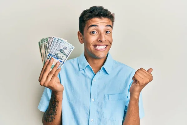 Joven Hombre Afroamericano Guapo Sosteniendo Dólares Gritando Orgulloso Celebrando Victoria —  Fotos de Stock