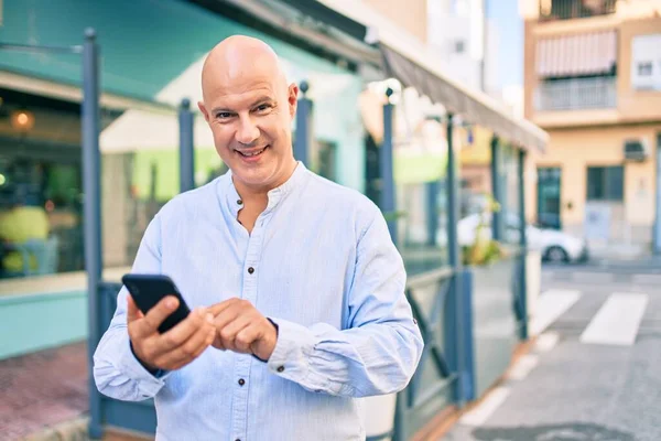 在城市里 中年秃头男人用智能手机开心地笑着 — 图库照片