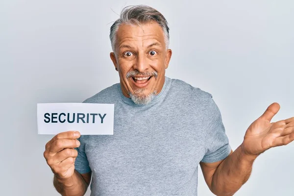 Hombre Pelo Gris Mediana Edad Sosteniendo Papel Palabra Seguridad Celebrando —  Fotos de Stock