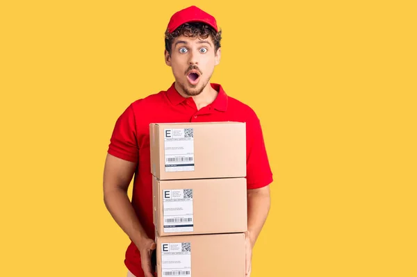 Jovem Homem Bonito Com Cabelo Encaracolado Segurando Pacote Entrega Assustado — Fotografia de Stock