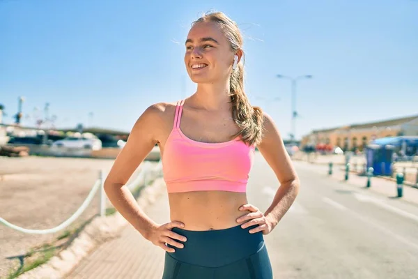 Jonge Blonde Sportvrouw Met Behulp Van Oortelefoons Doen Oefening Stad — Stockfoto