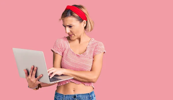 Młoda Blondynka Trzyma Laptop Myśląc Nastawienie Trzeźwy Wyraz Twarzy Patrząc — Zdjęcie stockowe