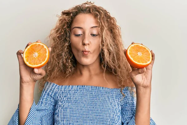 Hermosa Chica Adolescente Caucásica Sosteniendo Naranja Fresca Haciendo Cara Pescado —  Fotos de Stock