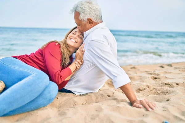 Pareja Hispana Mediana Edad Sonriendo Feliz Abrazándose Sentada Playa — Foto de Stock