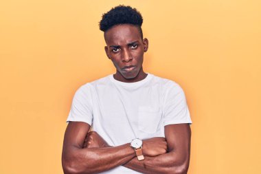 Gündelik kıyafetler giyen, kuşkucu ve gergin genç Afro-Amerikalı bir adam. Yüzünde çapraz kollarla onaylamayan bir ifade var. negatif kişi. 