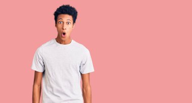 Genç Afro-Amerikan adam günlük kıyafetler giyiyor. Şaşırtıcı bir ifade, korku ve heyecan dolu bir yüz ifadesi var.. 