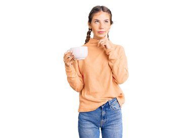 Güzel beyaz kadın, sarı saçlı, kahve içen, ciddi yüzlü, eli çenesinde soruyu düşünen, kafa karıştırıcı bir fikir. 