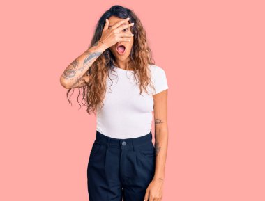 Dövmeli genç İspanyol bir kadın. Günlük beyaz tişört giyiyor. Şoka giriyor. Yüzü ve gözleri kapanıyor.. 