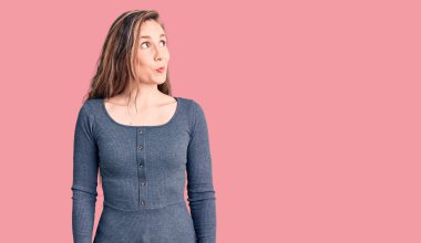 Genç, güzel, sarışın, sıradan bir elbise giyen, gülümseyen, yan bakan ve düşünen bir kadın.. 