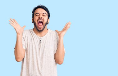 Gündelik kıyafetler giyen genç İspanyol adam başarı için deli ve çılgınlığı kutluyor kollarını kaldırmış ve gözlerini kapatmış heyecanla bağırıyor. Kazanan konsept 