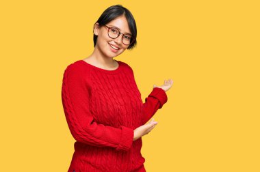 Kısa saçlı, sıradan süveter giyen ve gözlüklü genç, güzel İspanyol kadın gülümseyerek içeri girmeye davet ediyor. 