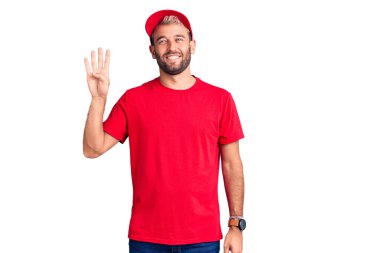 Tişört giyen ve şapkalı genç sarışın adam dört numarayı gösterip işaret ederken kendinden emin ve mutlu gülümsüyor.. 