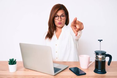 Ofiste çalışan esmer, esmer, esmer bir kadın kamerayı işaret ediyor ve sen kendine güvenen ciddi bir hareket yapıyorsun. 