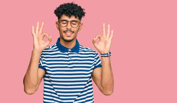 Młody Arabski Mężczyzna Luźnych Ubraniach Okularach Relaksuje Się Uśmiecha Zamkniętymi — Zdjęcie stockowe