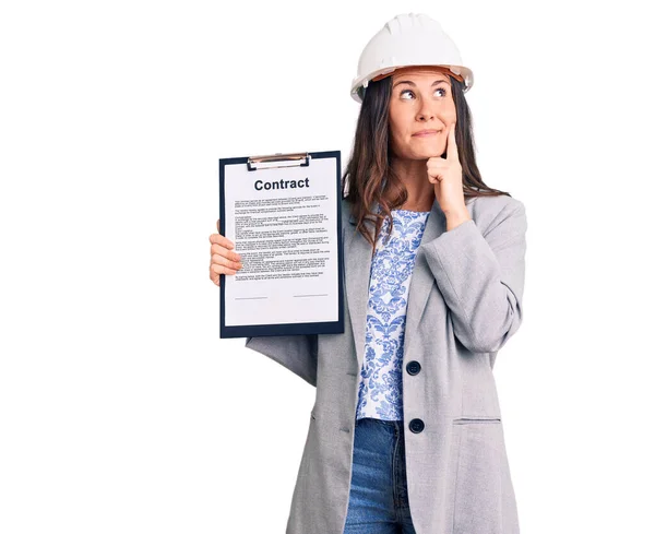 Jovem Bela Mulher Morena Vestindo Arquiteto Hardhat Segurando Contrato Rosto — Fotografia de Stock