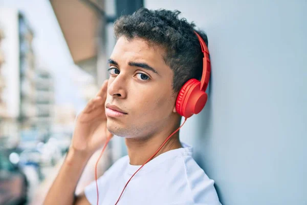 Joven Latino Con Expresión Seria Escuchando Música Usando Auriculares Ciudad —  Fotos de Stock