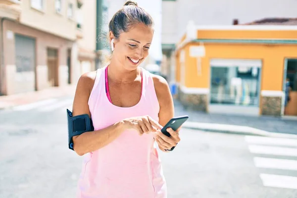 在城市里 中年女运动员用智能手机开心地微笑着 — 图库照片