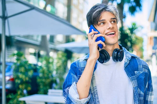 Νεαρός Ισπανόφωνος Χαμογελώντας Χαρούμενος Μιλώντας Στο Smartphone Και Χρησιμοποιώντας Ακουστικά — Φωτογραφία Αρχείου