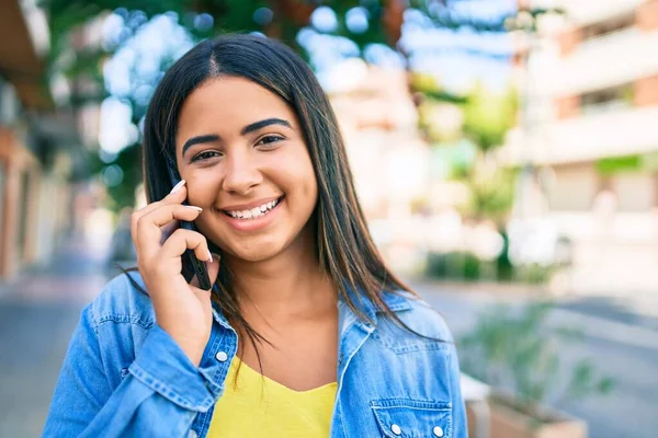 Young latin woman smiling happy talking on the smartphone at city