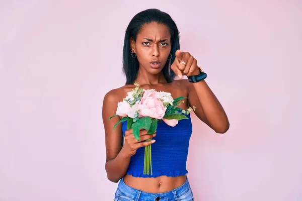 Mladá Africká Američanka Drží Květiny Ukazující Prstem Fotoaparát Vás Sebevědomé — Stock fotografie