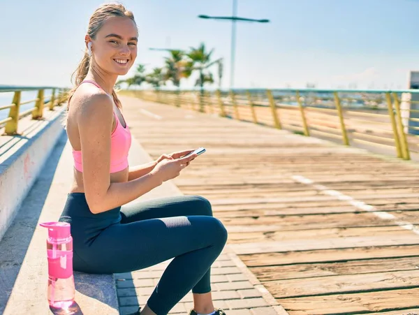 Jovem Esportista Loira Fazendo Exercício Usando Smartphone Sentado Banco Passeio — Fotografia de Stock