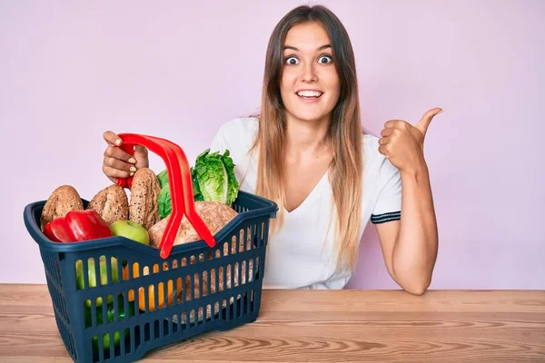 Hermosa Mujer Caucásica Sosteniendo Cesta Compra Del Supermercado Apuntando Pulgar —  Fotos de Stock