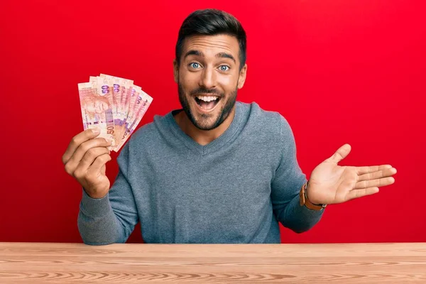 Hombre Hispano Guapo Sosteniendo Billetes Rand Sudafricanos Celebrando Logro Con —  Fotos de Stock
