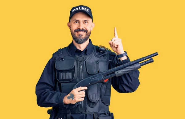 Jovem Bonitão Vestindo Uniforme Policial Segurando Espingarda Surpreso Com Uma — Fotografia de Stock