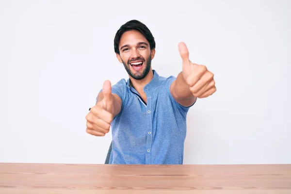 Bonito Hispânico Vestindo Roupas Casuais Sentado Mesa Aprovando Fazer Gesto — Fotografia de Stock