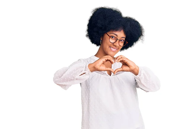 身穿休闲装的年轻的非洲裔美国女孩带着爱意微笑 用手表现出心灵的象征和形体 浪漫的概念 — 图库照片
