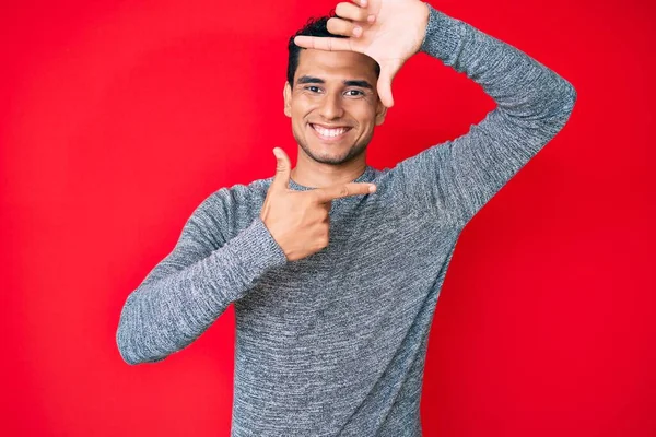 Joven Hombre Hispano Guapo Sobre Fondo Rojo Sonriendo Haciendo Marco —  Fotos de Stock