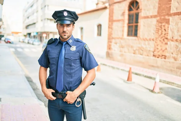 Joven Policía Hispano Guapo Vistiendo Uniforme Policía Pie Con Expresión —  Fotos de Stock