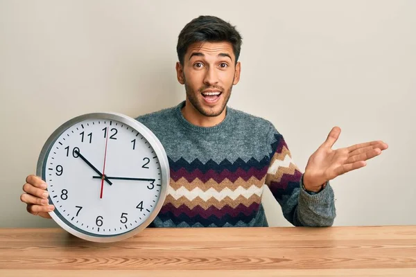 Joven Hombre Guapo Sosteniendo Gran Reloj Celebrando Logro Con Sonrisa —  Fotos de Stock