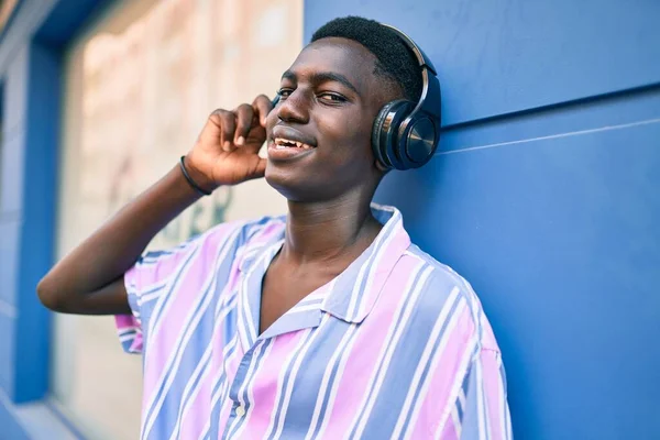 在城市街道上使用耳机的年轻的非洲裔美国人 — 图库照片