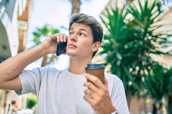 Νεαρός Καυκάσιος Άνδρας Σοβαρή Έκφραση Μιλάει Στο Smartphone Και Πίνει — Φωτογραφία Αρχείου