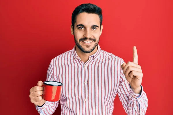 Joven Hispano Sosteniendo Café Sonriendo Con Una Idea Pregunta Apuntando — Foto de Stock