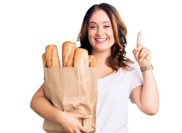 Молода Красива Біла Жінка Тримає Паперовий Мішок Хлібом Здивована Ідеєю — стокове фото