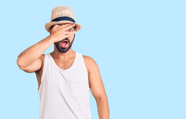 Young Hispanic Man Wearing Casual Summer Hat Peeking Shock Covering — Stockfoto