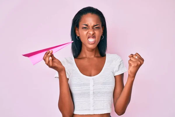 Joven Mujer Afroamericana Sosteniendo Avión Papel Molesto Frustrado Gritando Con —  Fotos de Stock