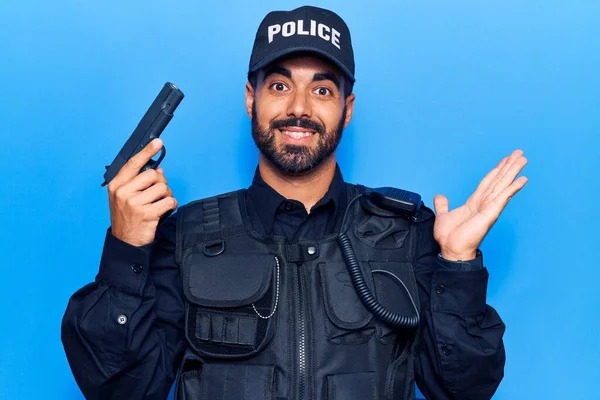 Young Hispanic Man Wearing Police Uniform Holding Gun Celebrating Achievement — Stock Photo, Image