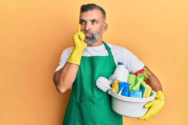 Middle Age Handsome Man Holding Cleaning Products Serious Face Thinking — 图库照片