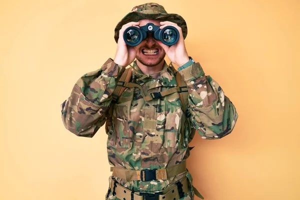 双眼鏡を使ってカモフラージュ軍の制服を着た若い白人男性は懐疑的で緊張し 問題のために動揺して眉をひそめていた 否定的な人 — ストック写真