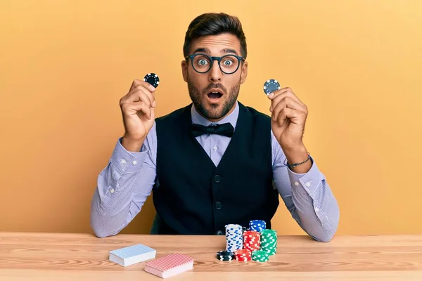 Bonito Croupier Hispânico Homem Sentado Mesa Segurando Fichas Casino Com — Fotografia de Stock